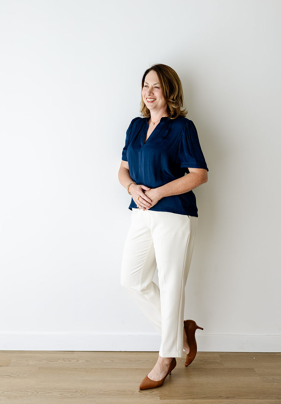 Woman in navy top and white pants
